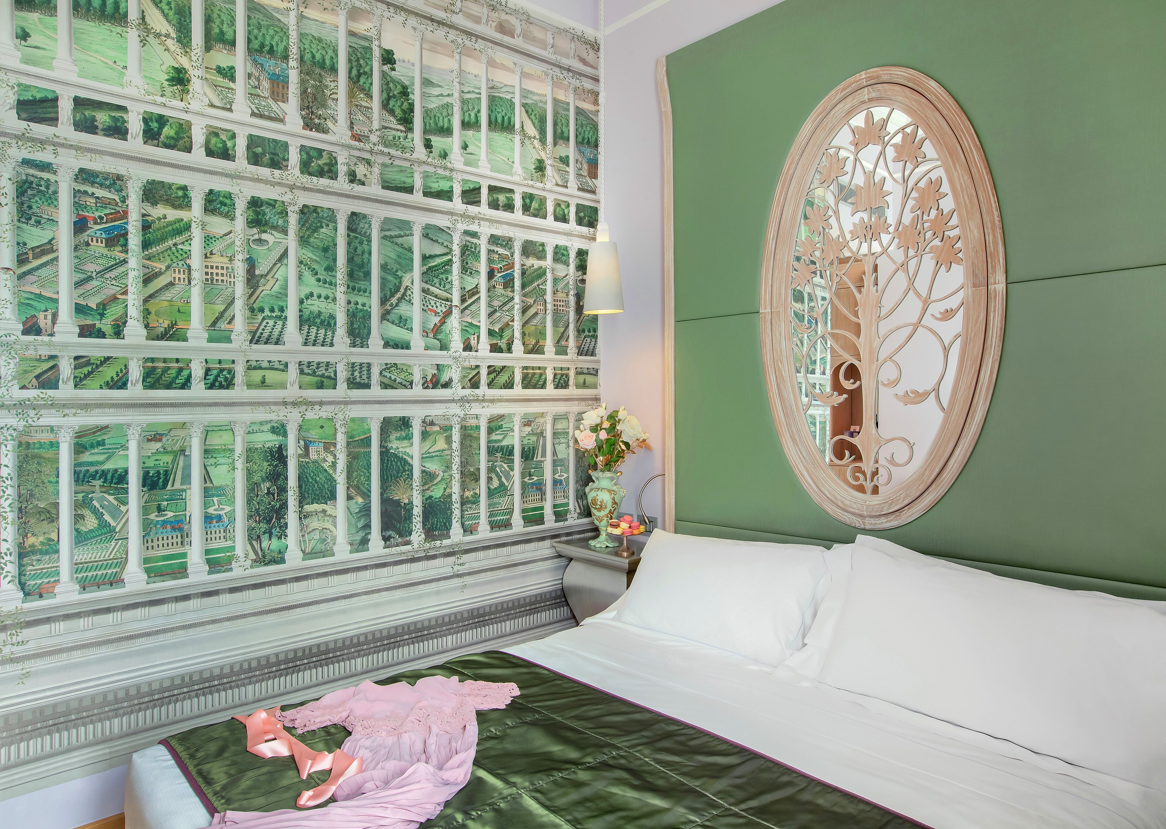 Quarto com uma janela grande, parede verde e um espelho decorativo.
