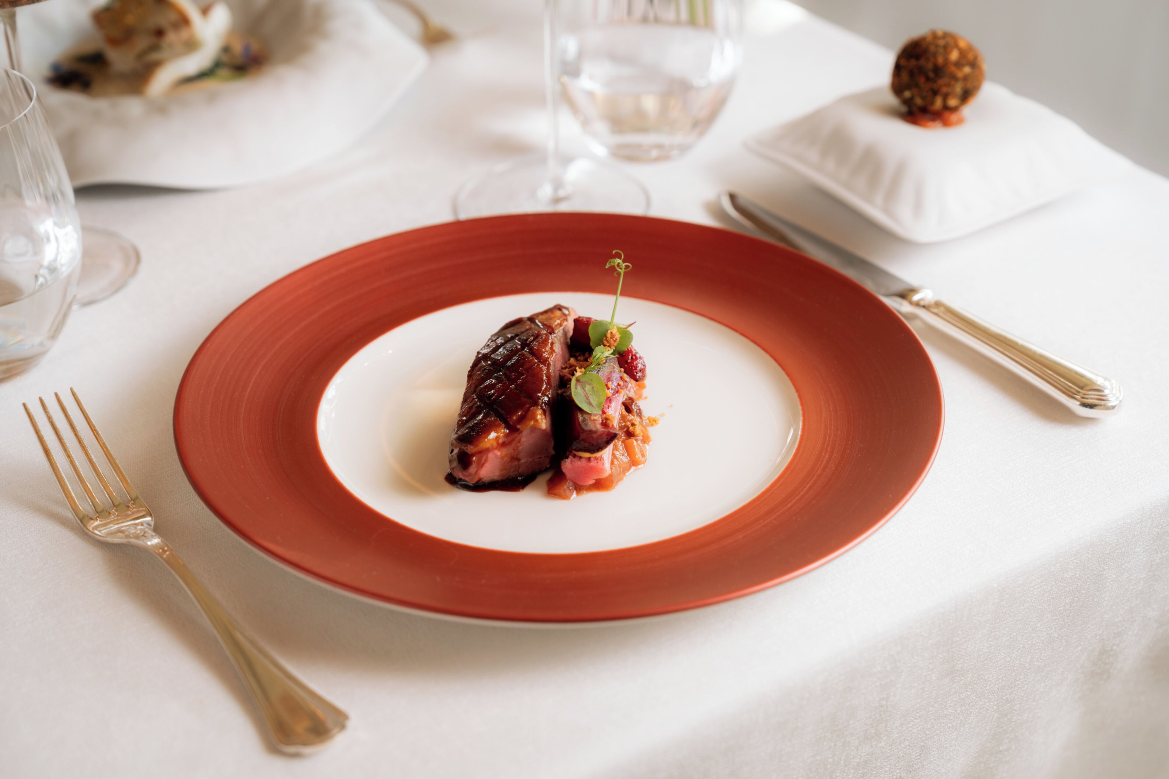 A plate of food on a table with a fork and knife to the side.