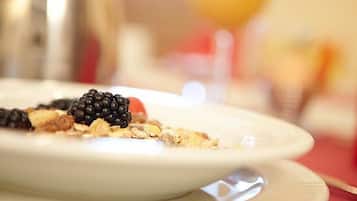 Ein Teller mit Kuchenstück, belegt mit Brombeeren und Nüssen.