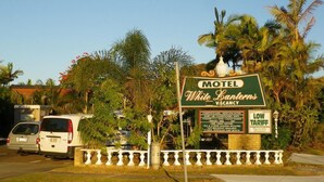 Letrero de motel que detalla los servicios, incluyendo tarifas económicas y atención amable.