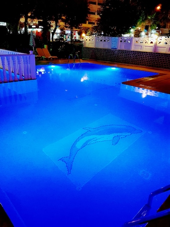 Una piscina al aire libre de temporada, sombrillas