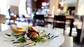 Un plato de comida con énfasis en el plato y un fondo borroso de un comedor.