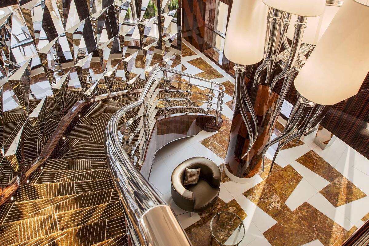 A modern interior with geometric patterned walls, a polished marble floor, and contemporary furniture.