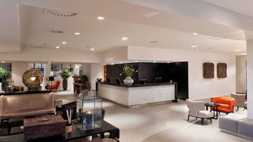 A modern lobby with a reception desk, seating area, and decorative elements.