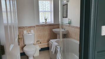 Une salle de bain avec des toilettes, un lavabo et une baignoire.