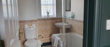 A bathroom with a toilet, sink, and bathtub.