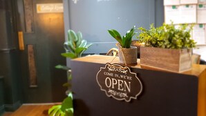 Ein Empfangsschalter mit einem Schild, auf dem 'The Luggier Inn' und 'GEÖFFNET' steht.
