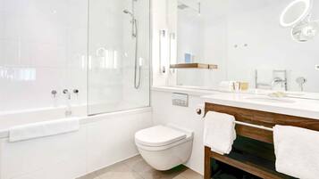 A modern bathroom with a glass-enclosed shower, a white toilet, and a vanity with a mirror and sink.