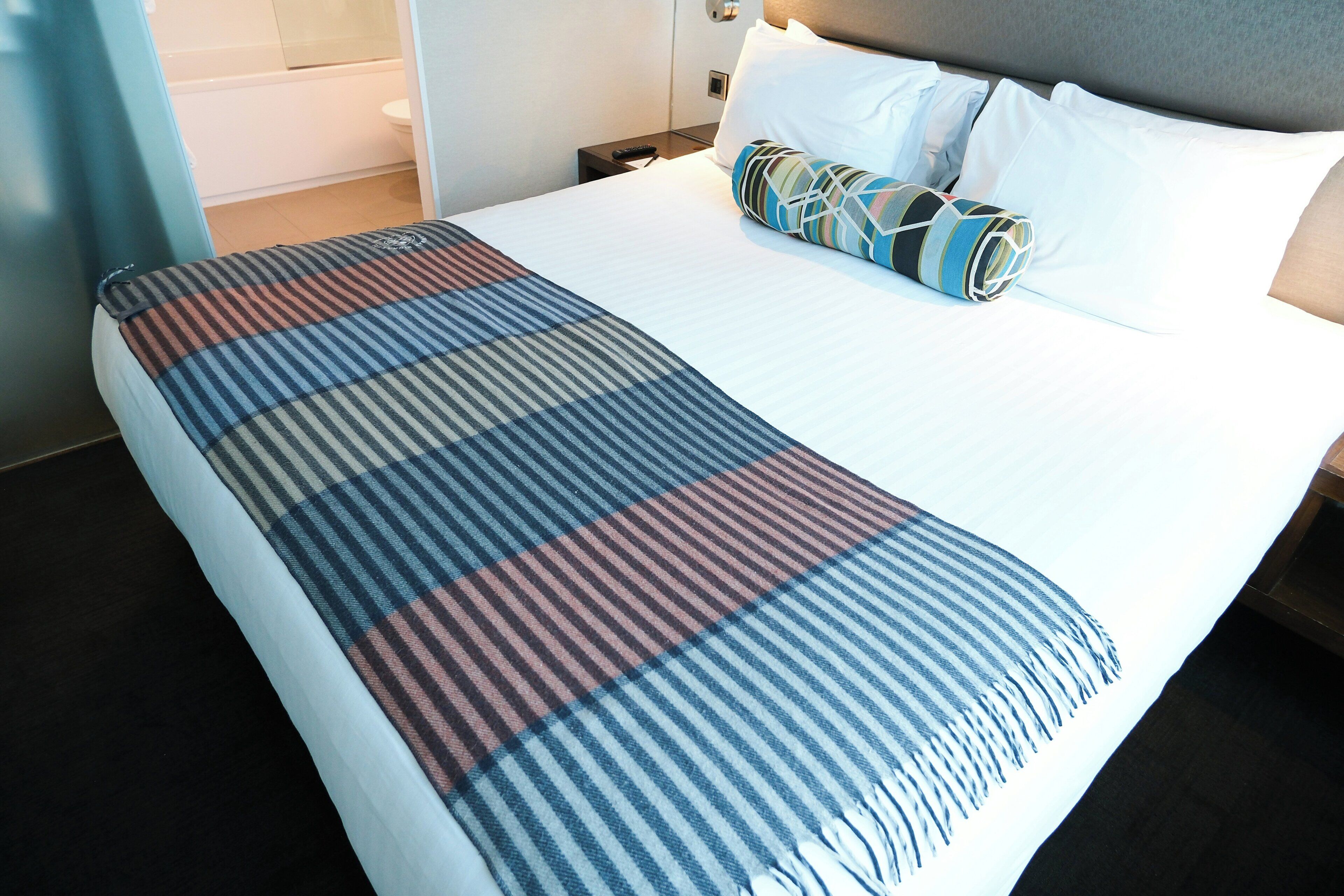 Une chambre d’hôtel avec un lit, une salle de bain et une table de chevet.