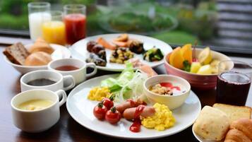 Une table dressée pour le petit-déjeuner, avec différents plats, boissons et pains.