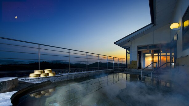 A hot spring area with a stone pool, wooden steps, and a railing. - WASHU BULE RESORT Kasago (Kurashiki)
