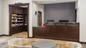 A hotel lobby with a snack bar, a reception desk, and a seating area. - TownePlace Suites Tucson Williams Centre (Tucson)