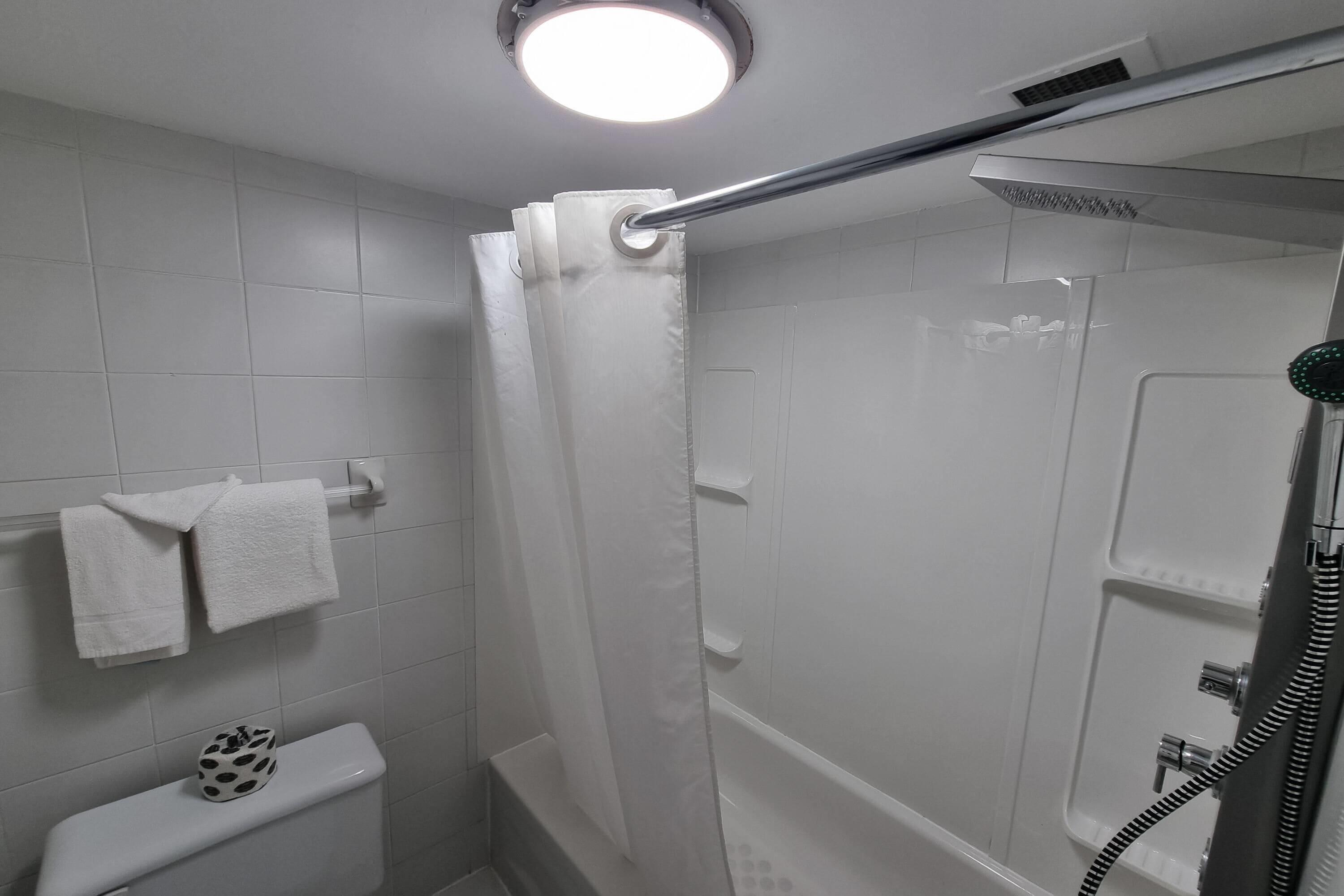 Un baño moderno con ducha, inodoro y toallero.