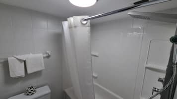 A modern bathroom with a shower, toilet, and towel rack.