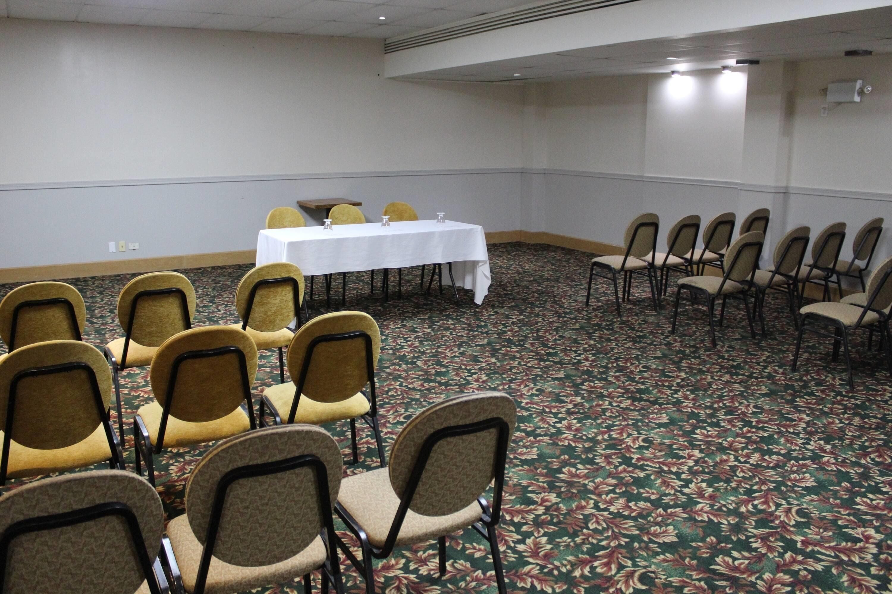 Una sala conferenze con un lungo tavolo e sedie disposte per una riunione.