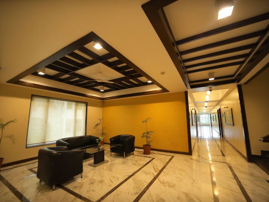 A spacious lobby with a high ceiling, a marble floor, and a seating area with sofas and a coffee table.