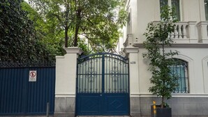 Una entrada con puerta metálica azul, señal de no estacionamiento y un edificio con el número 428 en la pared.