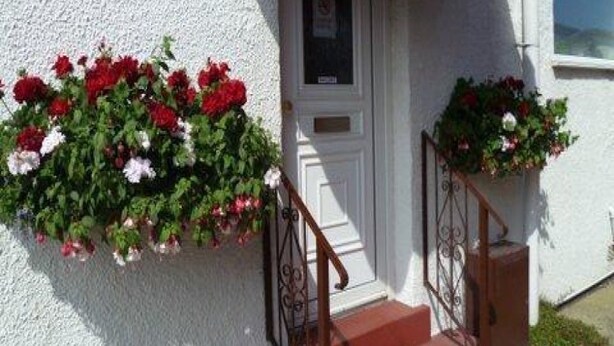 A white building with a red door and a small window above it. - Belvedere Guest House, Great Yarmouth (Great Yarmouth)