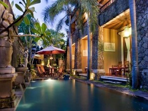A stone building with a pool, outdoor seating, and tropical plants. - Sindhu Mertha Sanur (Denpasar)