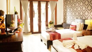 Habitación de hotel con dos camas, televisión, escritorio y ventana con cortinas.