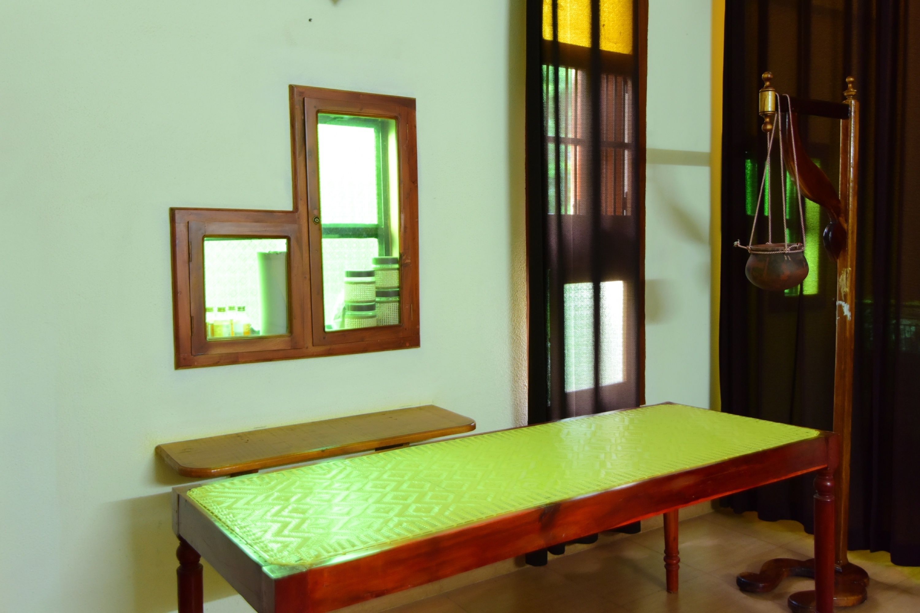 A room with a wooden bench, a small table, and a traditional balance scale.