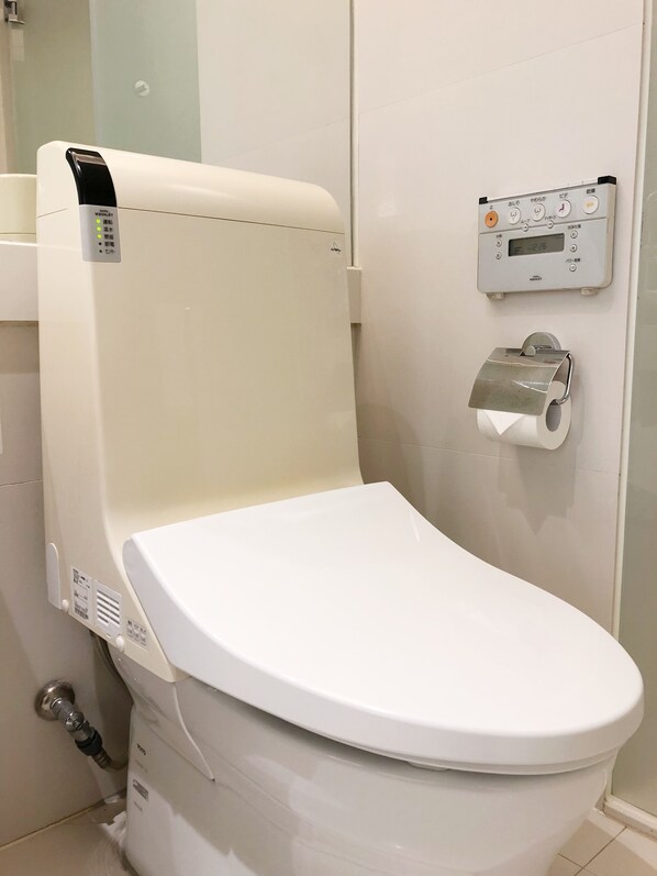 Un inodoro moderno con panel de control y dispensador de papel higiénico.