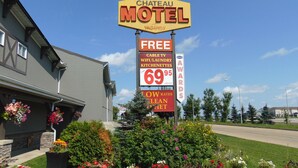 Schild des Chateau Motel, das folgende Annehmlichkeiten anbietet: kostenloses WLAN, Wäscheservice und Küchenzeilen.