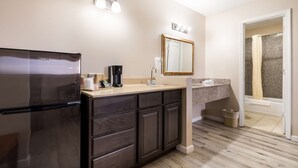 Un baño moderno con lavamanos, espejo y ducha.