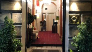 A hotel entrance with a red carpet, a chandelier, and a reception desk. - Atlas Guest House (Edinburgh)