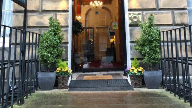 The entrance of Atlas House with a stone facade, a black signboard, and a small entrance area with potted plants. - Atlas Guest House (Edinburgh)