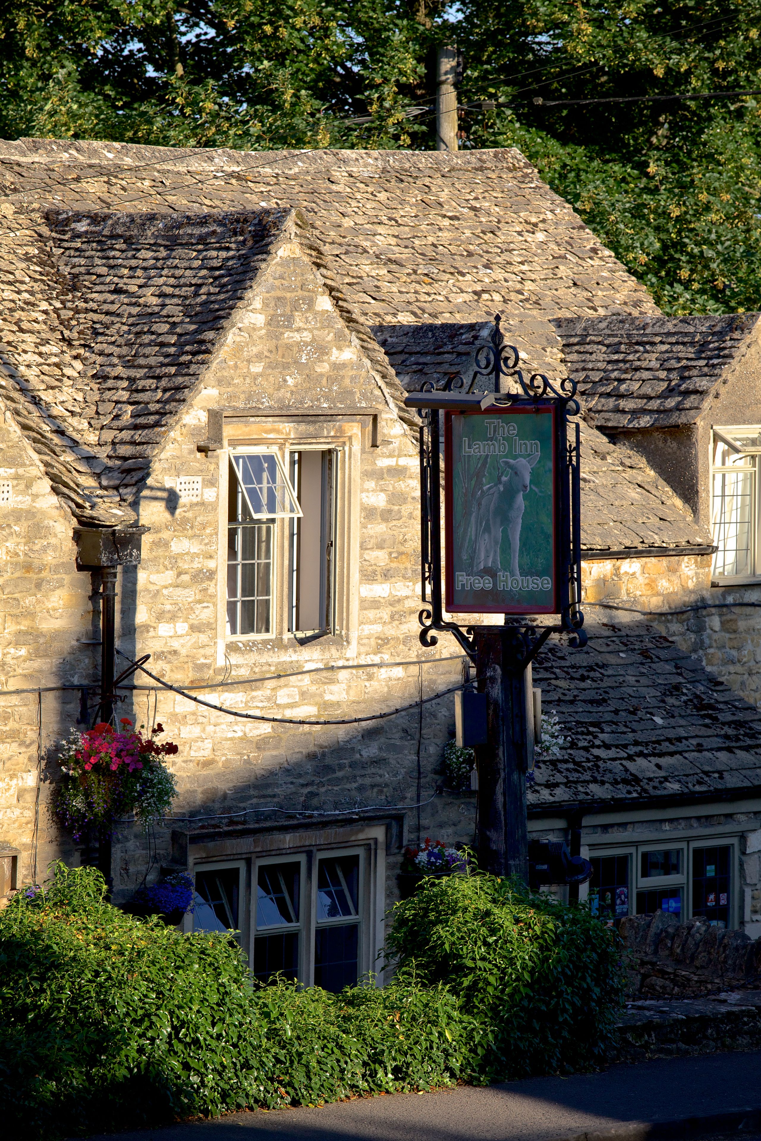 A stone building with a sign for The Lamb Inn Free House.