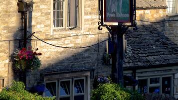 A stone building with a sign for The Lamb Inn Free House.