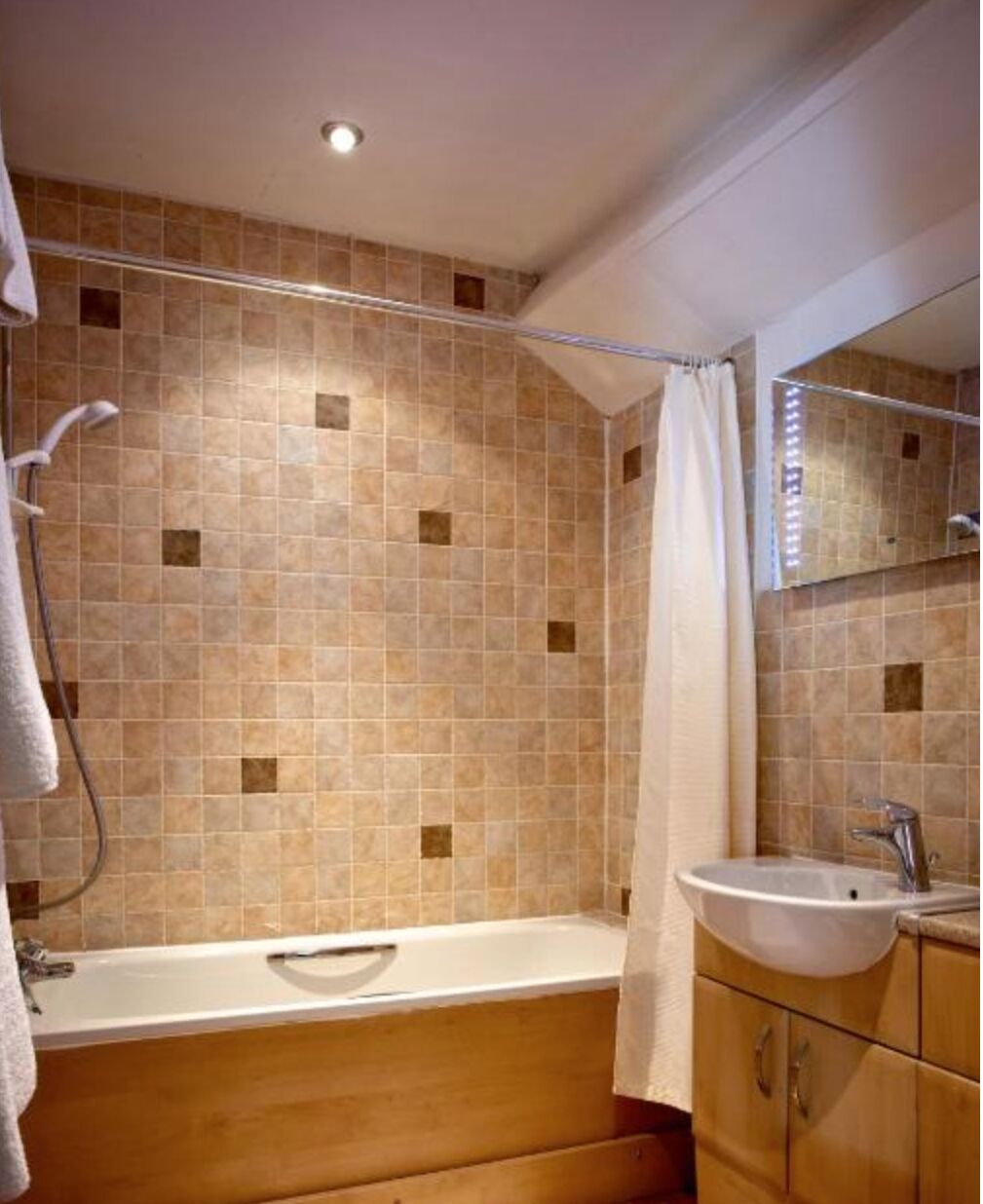 A bathroom with a bathtub, a shower, a sink, and a mirror.