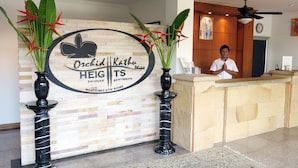 Una recepción con un cartel de Orchid Kathie Heights Apartments, que muestra un logotipo y un mensaje de bienvenida.