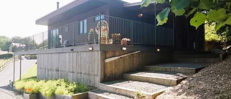 Ein modernes Gebäude mit flachem Dach, einem Balkon mit Metallgeländern und einer Treppe zum Eingang.