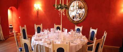 Comedor con una mesa redonda dispuesta para seis personas, rodeada por seis sillas con cojines azules.