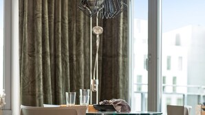 A modern dining area with a glass table, two chairs, and a pendant light. - BJØRVIKA APARTMENTS, Teaterplassen, Oslo city center (Oslo)