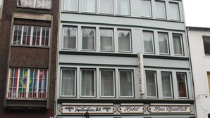 Ein zweistöckiges Gebäude mit einem Schild, das es als Hotel namens 'Hotel Haus Rheinblick' kennzeichnet.