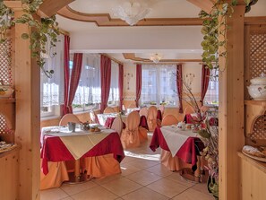 A dining area with multiple tables, red and white tablecloths, and chairs. - Al Posta Hotel 1899 (Baselga di Pine)