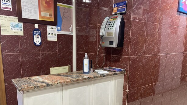 Un mostrador de recepción con encimera de mármol, un teléfono y un directorio.