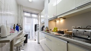 Una cocina moderna con electrodomésticos de acero inoxidable, una cafetera y diversos alimentos sobre la encimera.