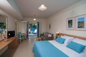 Ein Hotelzimmer mit Bett, Schreibtisch, Stuhl, Fernseher und Blick ins Freie.