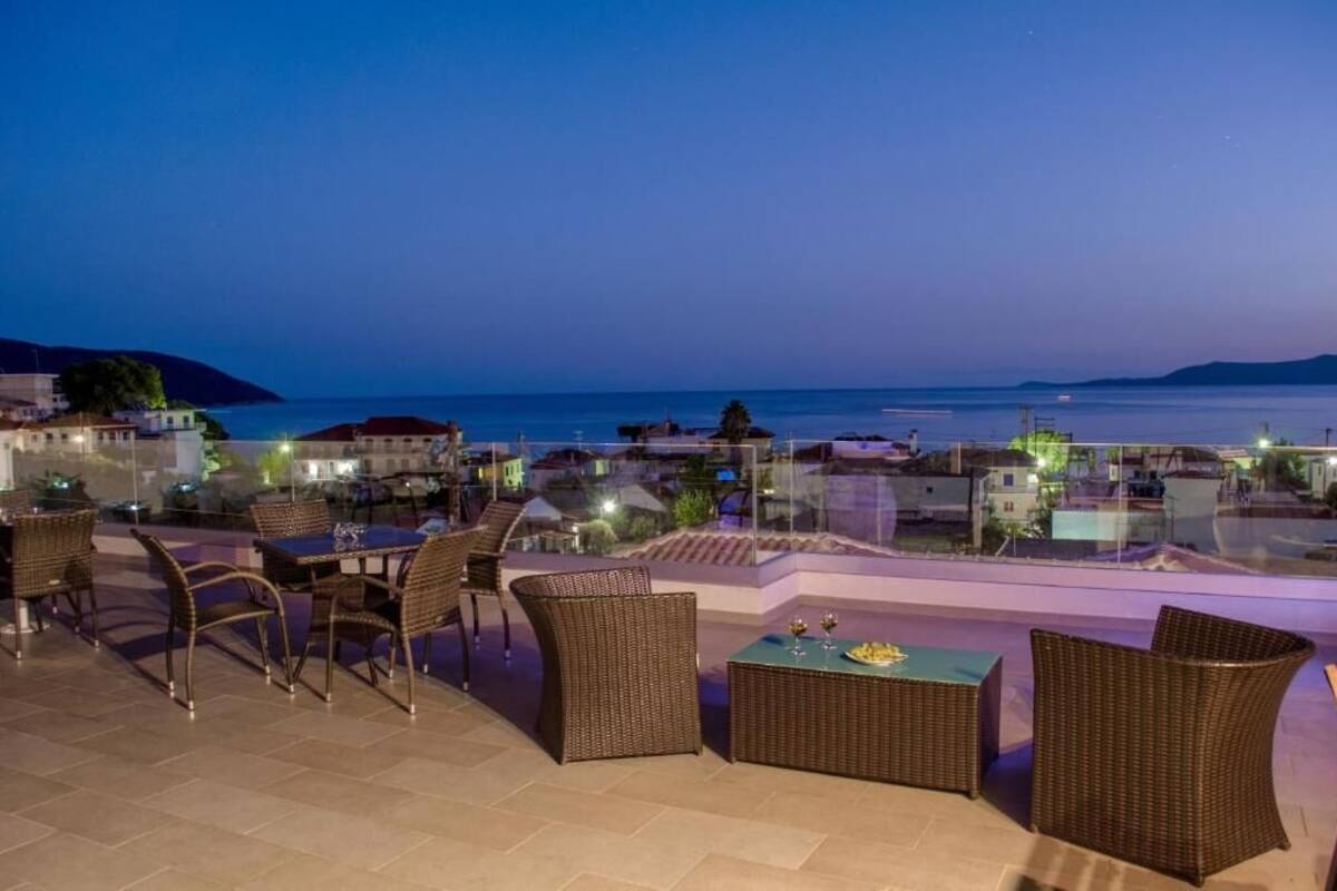 A terrace with wicker furniture and a view of the sea at dusk.