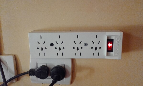 A power strip with multiple outlets and a red indicator light.