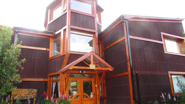 A multi-story wooden building with a prominent corner entrance and large windows. - Hosteria Les Eclaireurs (Ushuaia)