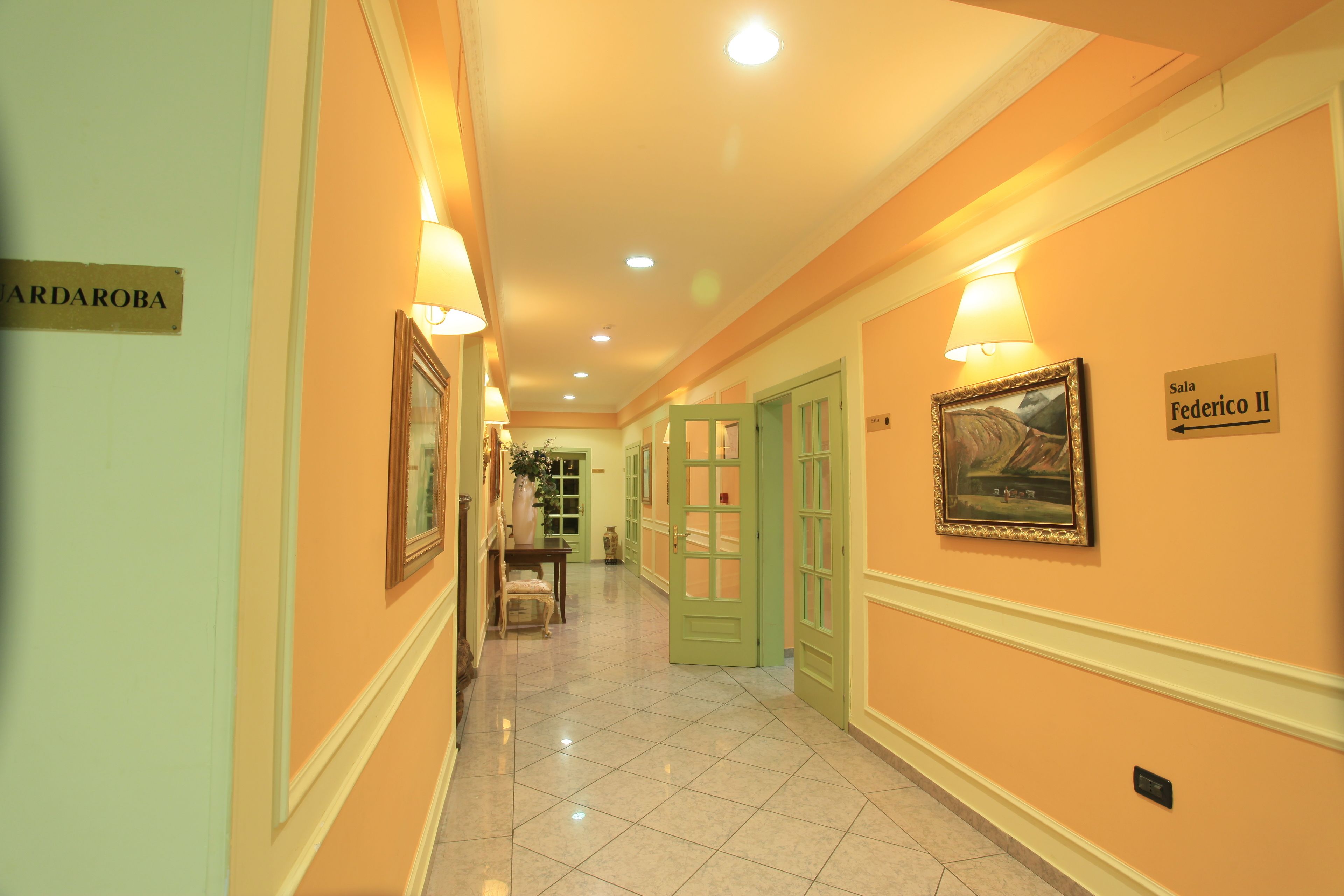 A hotel corridor with a sign for 'Sala Federico II' and a sign for 'CARDAROBA'.