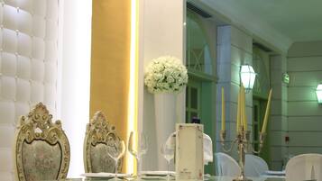 Una tavola apparecchiata con porcellane pregiate, un candelabro e un'elegante composizione floreale.