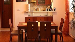 Une cuisine compacte comprenant une table et des chaises, un petit plan de travail et un meuble suspendu au-dessus de l’évier.