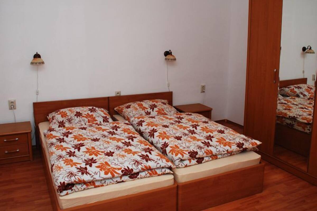 Una camera da letto con un letto matrimoniale, due comodini, un armadio e uno specchio.