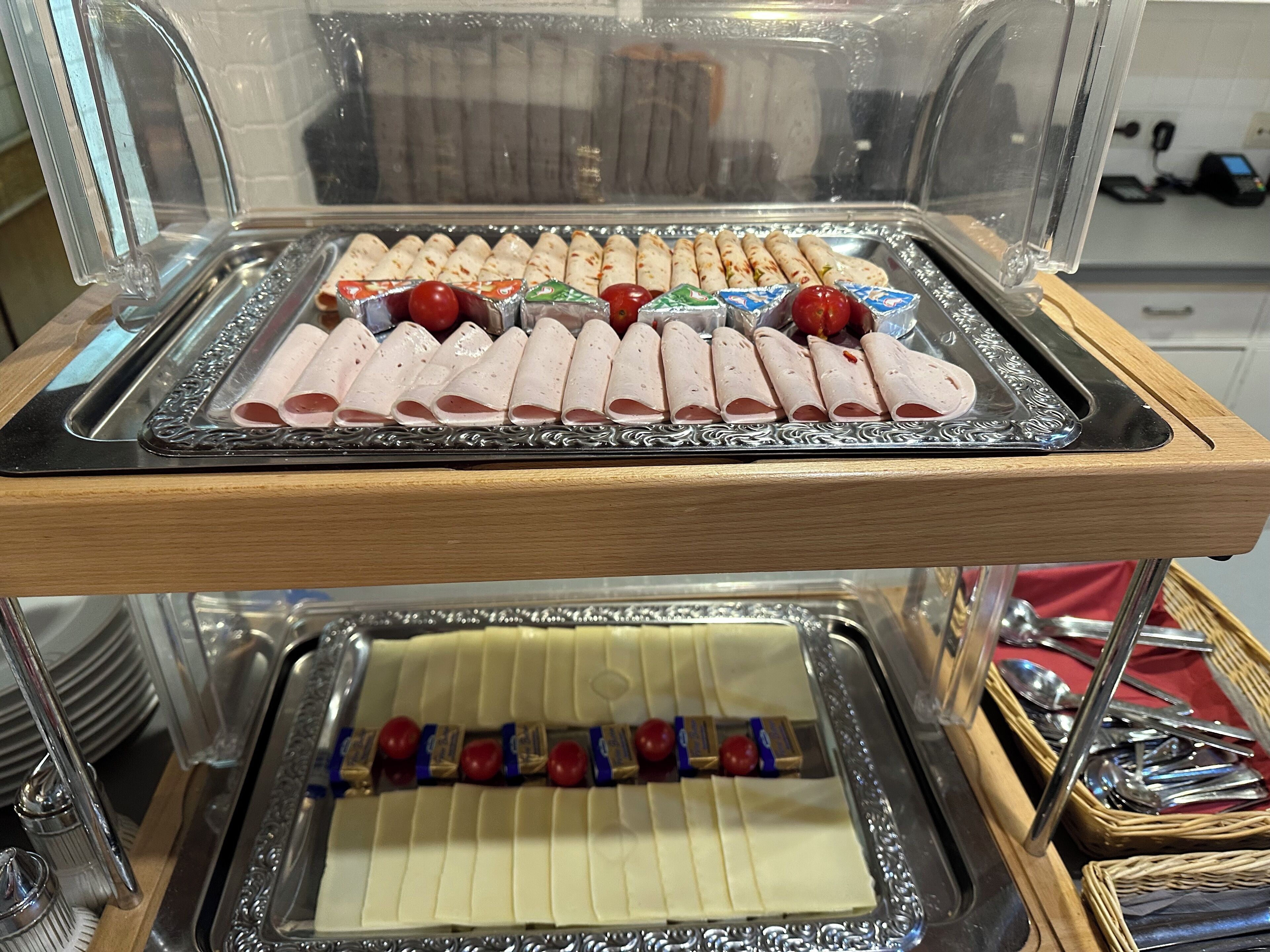Ein reichhaltiges Buffet mit ordentlich angerichteten Speisen, darunter geschnittenes Fleisch und Obstspieße.